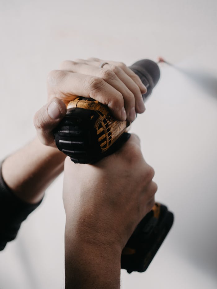 close-up-of-man-holding-drill-against-wall-15406537 Landlord Property Maintenance: expert repairs,